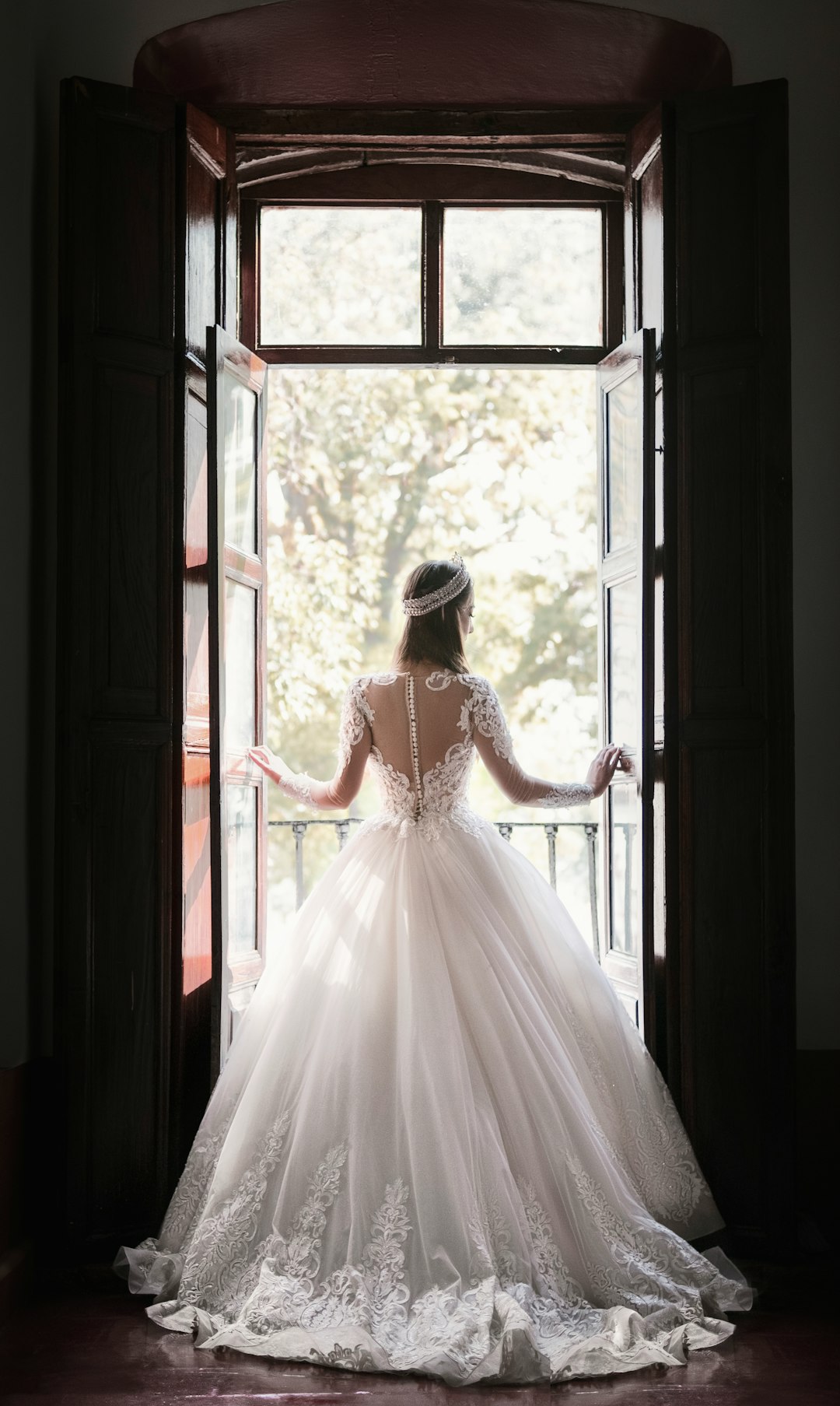 Vale & Ivory bride in white gown by a window