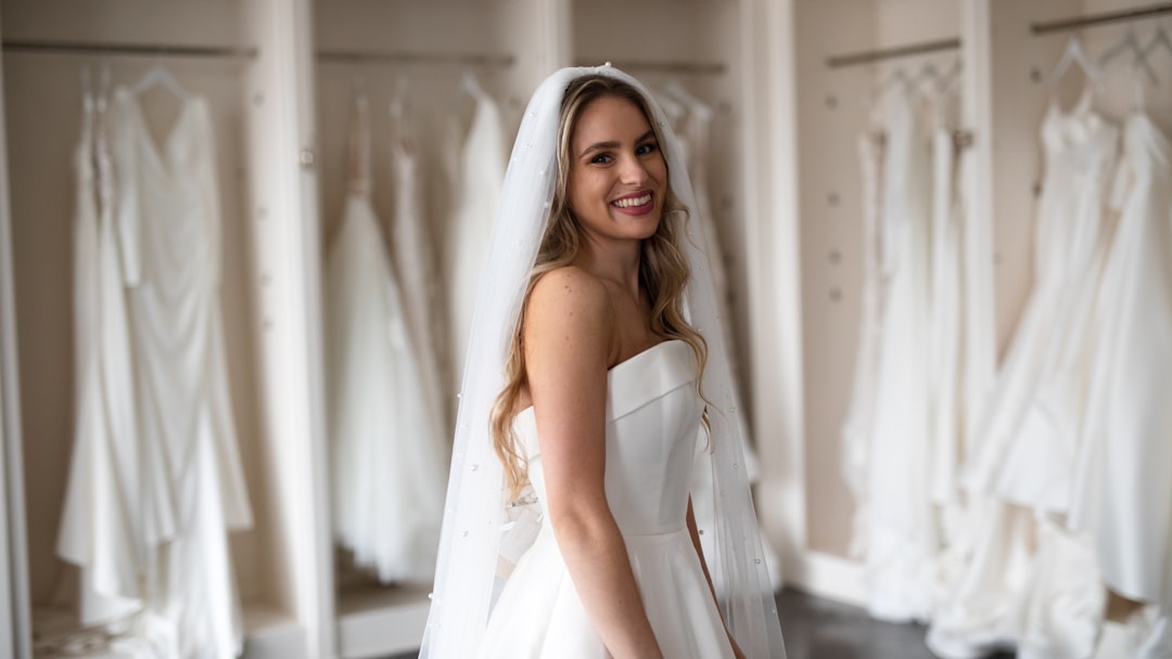 Woman browsing a row of wedding dresses in a bridal boutique